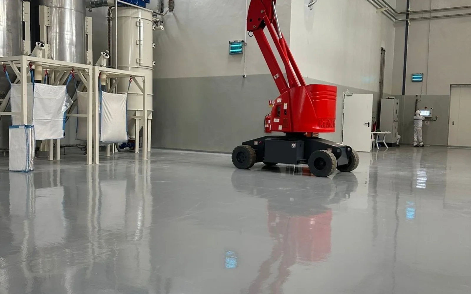 Nacelle araignée sur chenilles EasyMat stabilisée sur un sol résine en intérieur